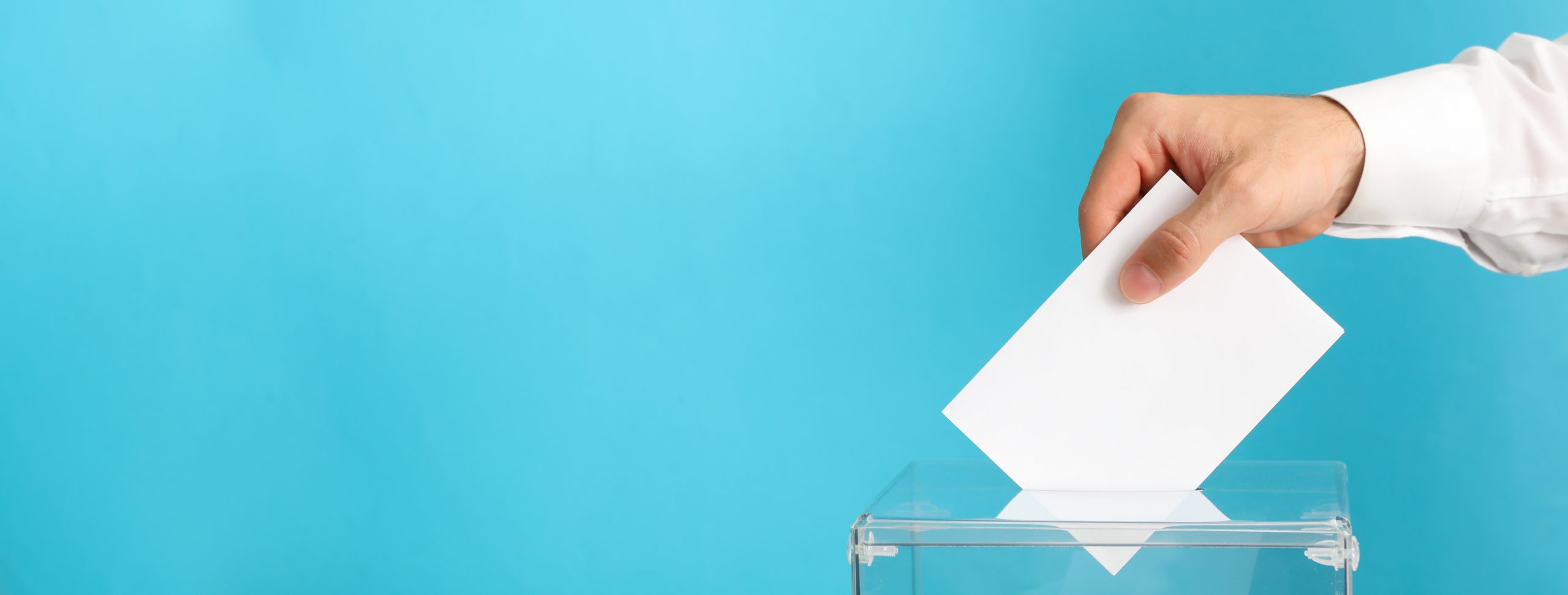 Man putting ballot into voting box on blue background
